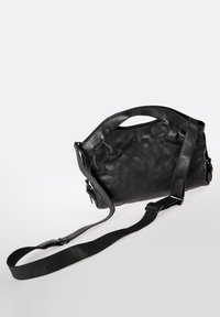 Zwarte leren tas met een gladde textuur, gebogen ontwerp, bovenhandvat en verstelbare schouderriem. Geen zichtbare hardware of patronen.