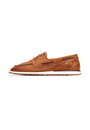 Zapato de barco de cuero marrón con punta redondeada, detalles de costura, cierre con cordones y suela de goma blanca con una franja de acento roja.