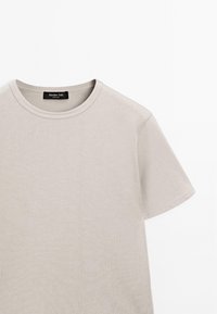Lys grå kortærmet t-shirt lavet af blød bomuld. Har en rund halsudskæring og et minimalistisk design uden mønstre eller accenter.