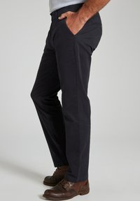 Pantaloni navy in misto cotone, con vestibilità slim e tasche laterali. Abbinati a scarpe stringate marrone scuro.