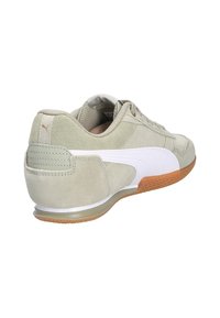 Las zapatillas Puma cuentan con un upper de ante verde claro, acentos de cuero blanco y una suela de goma. El diseño incluye un logo en el talón.