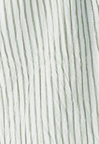 Tkanina s črtami, ki potekajo navpično v beli in svetlo zeleni barvi. Tekstura je rahlo nagubana, z gladkim zaključkom.