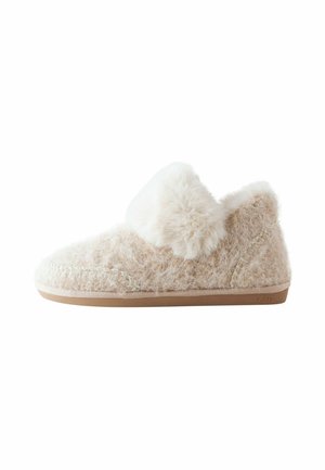 Chaussons en beige avec un col doux et duveteux. Équipés d'une semelle en similicuir et d'un extérieur texturé pour plus de chaleur et de confort.