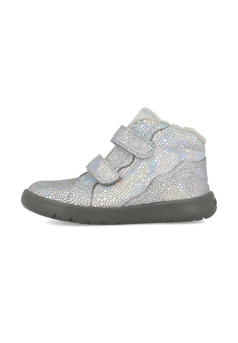 Botas de tobillo plateadas con textura, dos correas de velcro, un forro suave y una suela de goma gris, mostrando una superficie reflectante y con patrón.