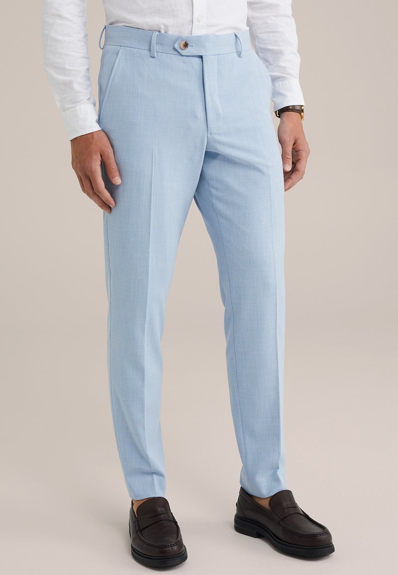 Világoskék, szabott nadrág, texturált anyagból, gombos záródással, két oldalsó zsebbel és slim fit szabással. Sötétbarna mokaszinokkal párosítva.