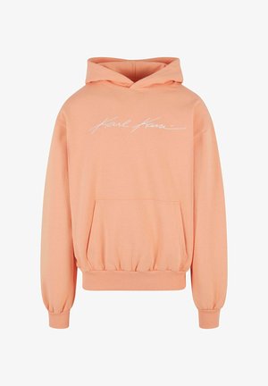 Pfirsichfarbene Kapuzenpullover mit einer Vordertasche, elastischem Saum, gerafften Ärmeln und weißem "Karl Kani" Logo auf der Brust. Weiche Stoffbeschaffenheit.