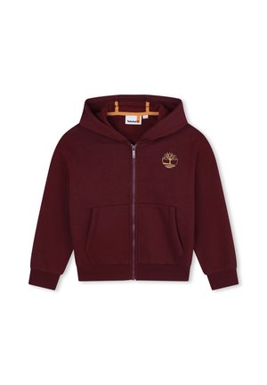Veste à capuche zippée bordeaux avec une poche avant, une capuche, des poignets et une taille côtelés. Présente un logo doré d'arbre sur la poitrine gauche. Texture douce.