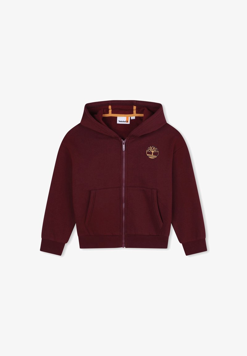 Veste à capuche zippée bordeaux avec une poche avant, une capuche, des poignets et une taille côtelés. Présente un logo doré d'arbre sur la poitrine gauche. Texture douce.