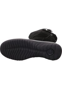 Bota de ante negra con suela de goma texturizada, que presenta una forma curva y un detalle de botón redondo en la suela.