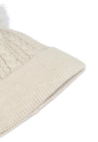 Berretto lavorato a maglia di colore crema con una spessa bordo a costine e motivi a treccia in rilievo; rifinito con un morbido e soffice pompon decorativo.