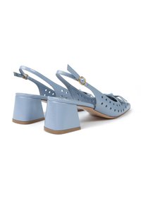 Jasnoniebieskie lakierowane buty na słupku z perforowanym wzorem, kwadratowe obcasy oraz złote akcenty na pasku.