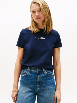 Tricou din bumbac de culoare bleumarin, cu mâneci scurte, având brodat în alb textul "Tommy Hilfiger". Asortat cu blugi din denim ușori, cu talie înaltă.