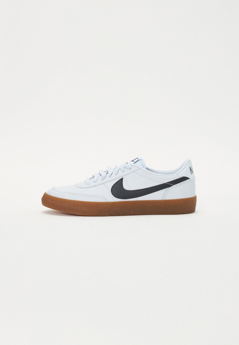 Gaiši zili zemāko sporta apavu modeļi, kas izgatavoti no ādas, ar melnu swoosh logotipu un gumijas zolēm. Iezīmējas ar apaļu šņoru un mīkstu oderējumu.