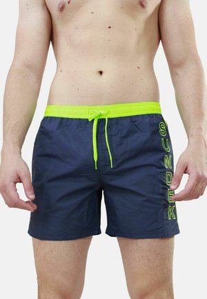 Shorts da nuoto blu navy con coulisse e dettagli verde neon. Presentano la scritta "SUNDEK" stampata verticalmente sul lato sinistro. Materiale leggero e ad asciugatura rapida.