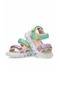 Sandalias infantiles coloridas con malla en verde menta, lavanda y rosa, con correas de Velcro y suela de goma blanca.