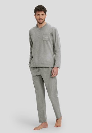 Conjunto de loungewear gris en tejido suave, que incluye una camiseta de manga larga con un bolsillo en el pecho y pantalones a juego de corte relajado.