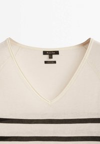 Pull à col en V crème avec des rayures noires horizontales. Présente une texture douce et lisse ainsi qu'un design minimaliste, étiqueté par Massimo Dutti.