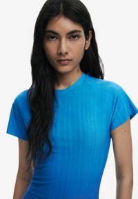 Blue fitted t-shirt with a smooth texture, short cap sleeves, and a gradient color effect from lighter to darker blue.