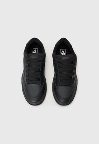 Black low-top sneakers made of synthetic leather and fabric, featuring round toes, flat laces, and a textured surface.