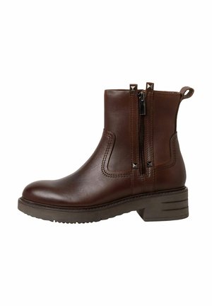 Bottine en cuir marron avec un bout rond, deux fermetures éclair sur les côtés et des accents cloutés. Talon bas en bloc et semelle texturée.