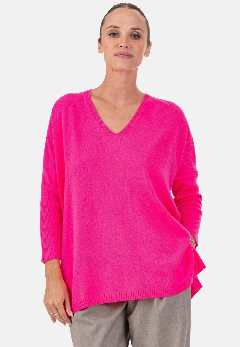 Pull rose col en V avec manches longues et coupe décontractée. Fabriqué en matériau doux avec ourlet et poignets côtelés.