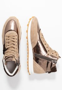 Beżowe i metaliczno-brązowe trampki za kostkę z zamszowymi i teksturowanymi detalami, wyposażone w boczny zamek błyskawiczny oraz białą gumową podeszwę.