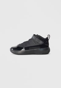 Baskets de sport noires à tige haute, avec des textures brillantes et mates, une bande Velcro et des détails perforés pour la respirabilité.