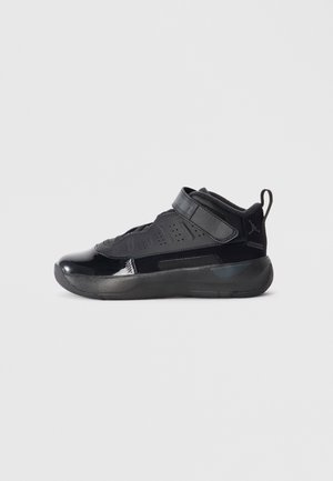 Baskets de sport noires à tige haute, avec des textures brillantes et mates, une bande Velcro et des détails perforés pour la respirabilité.