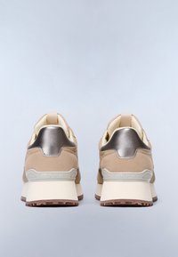 Un paio di sneaker in suede beige e retro metallico con suole bianche spesse e suole esterne marroni testurizzate su sfondo grigio chiaro.