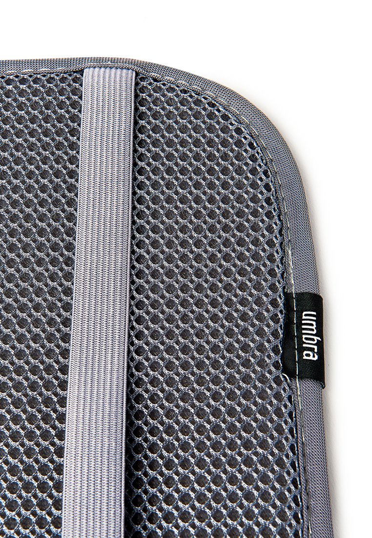Gros plan sur un support lombaire en mesh gris avec une sangle élastique et une étiquette en tissu portant la mention "umbra" sur fond blanc.