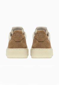 Sneaker in suede marrone con accenti beige, dotati di una tomaia in tessuto testurizzato, un inserto sul tallone a contrasto e una suola imbottita.