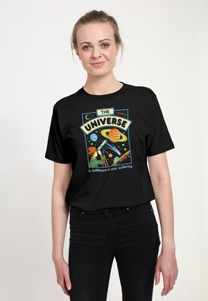 Sort t-shirt med et farverigt grafisk tryk af planeter, et teleskop og teksten "THE UNIVERSE er ligeglad med din lidelse."