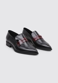 Mocasines de cuero negro con puntas afiladas, con una banda burdeos en la parte superior. Tacón bajo cuadrado, diseño elegante y textura suave.
