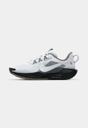 Weißer und schwarzer Nike Trailrunning-Schuh mit großem Swoosh-Logo, Mesh-Obermaterial, gepolsterter Sohle und Fersenlasche, seitlich vor weißem Hintergrund gezeigt.