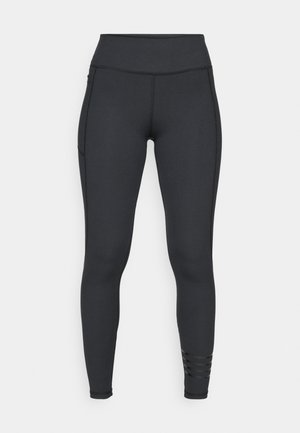 Black leggings made from stretchy material, featuring a high waistband, sleek design, and striped accent details near the ankle.