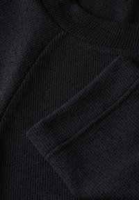 Pull en maille bleu marine foncé avec un tissu texturé, un col côtelé et une poche plaquée sur le devant.