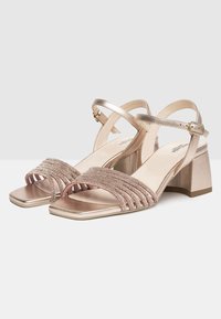 Sandali con tacco in oro metallico e rosa, con punta aperta, caratterizzati da più cinturini decorati con perline e un robusto tacco a blocco. Chiusura con fibbia alla caviglia.