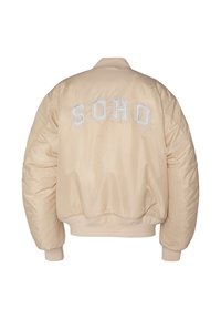 Beige bomberjakke med ribstrikkede manchetter og kant, med store hvide broderede bogstaver der staver "SOHO" på ryggen.