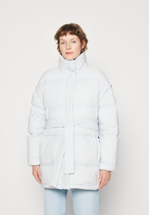 Veste légère et duveteuse bleu clair avec un col haut, une taille ceinturée et des manches longues. Présente une texture matelassée et des poches latérales.