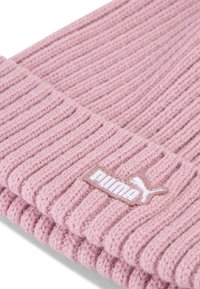 Berretto a maglia rosa con texture a coste. Presenta un logo Puma bianco ricamato su una toppa beige. Materiale morbido con una vestibilità aderente.