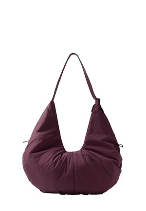 Sac à épaule doux et rembourré violet profond avec une large forme en croissant et une seule lanière étroite pour le porter.
