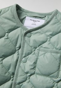 Kvadret lys grøn jakke med runde knapper, en lomme og en blød tekstur. Har en rund halsudskæring og et moderne design.