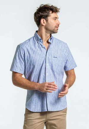 Chemise à manches courtes avec des rayures verticales bleues et blanches ; présente un col pointu, des accents cousus et une coupe décontractée.