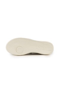 Suola in gomma di una sneaker color avorio con motivi di grip testurizzati. Presenta un logo e una suola intermedia liscia grigia, progettata per un uso casual.
