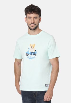 Camiseta de algodón verde menta con un gráfico de un oso de peluche en un patinete con el texto "La Vespita". Mangas cortas y cuello redondo.