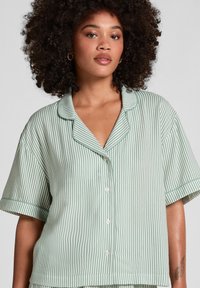 Groen en wit gestreepte kortarmige overhemd met een notch-kraag en een relaxte pasvorm. Zachte stof met een gladde textuur en zichtbare knopen.
