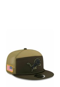 Olivgrüner Hut mit einem strukturierten Netzrücken, flacher Krempe und gesticktem schwarzem Löwenlogo. Auf der Seite befindet sich ein Aufnäher mit der US-Flagge.