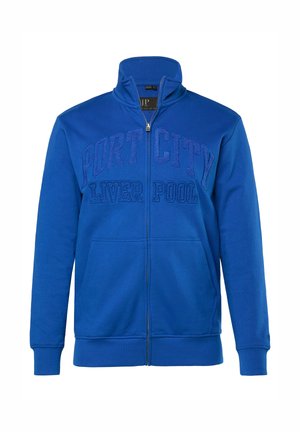 Royal blå lynlåstrøje med høj krave, der har et tekstureret grafisk "PORT CITY LIVER POOL" på tværs af brystet og frontlommer.