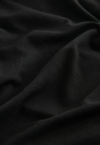 Tessuto nero con una texture liscia, caratterizzato da morbide pieghe e una leggera lucentezza, che mette in risalto la sua natura leggera e flessibile.