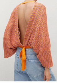 Haut tricoté à motifs en zigzag aux couleurs vives, dos ouvert, détail de lien orange à la taille, manches larges et coupe ample.